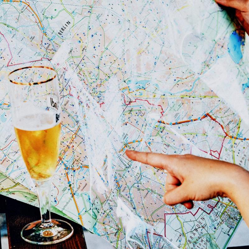 Close up of cropped hand holding tourist map with beer