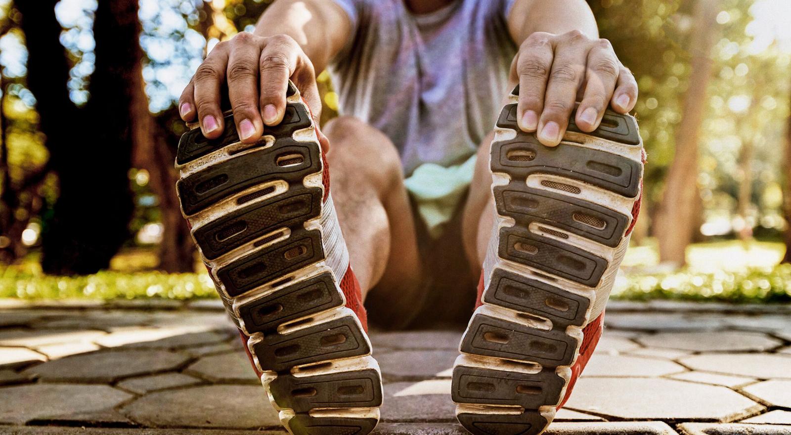 Large Web and Screen Man touching his toes while strectching