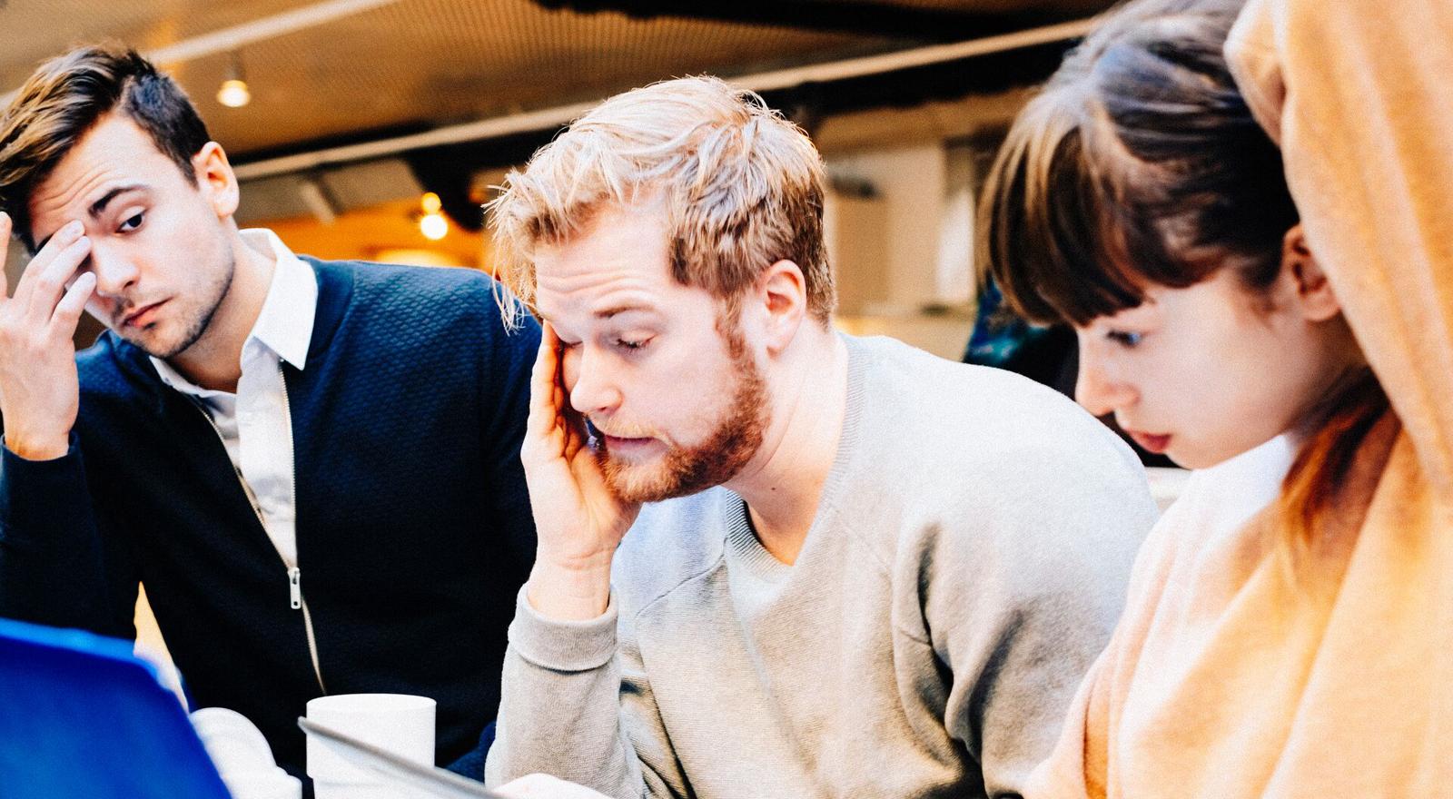 Large Web and Screen Three stressed colleagues sit together at an office business meeting