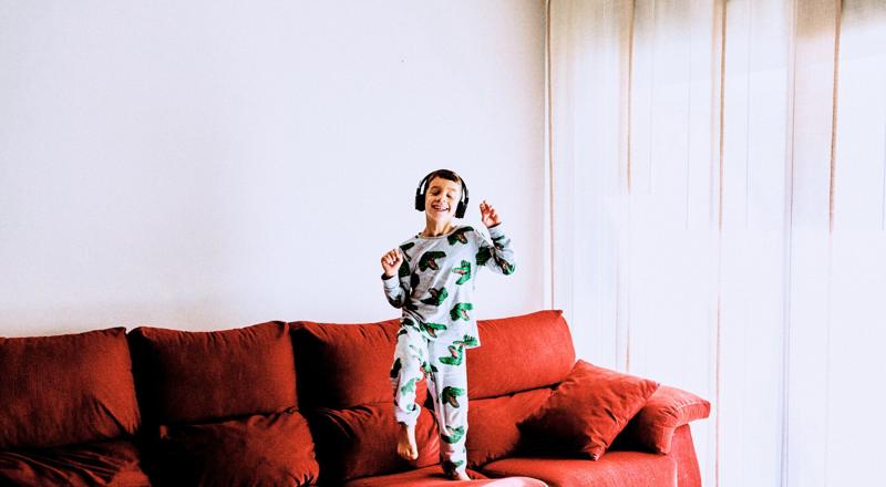 young boy is listening music on sofa young boy is listening music on sofa