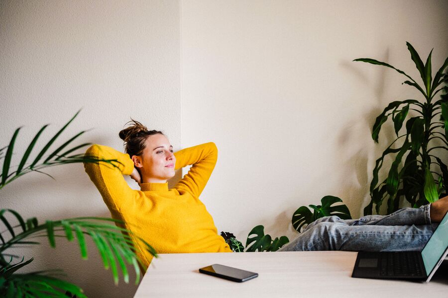 Medium Office 365 and Newsletters Young woman in yellow sweater reclining at her desk