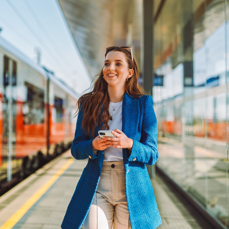 Young worker at train station on phone